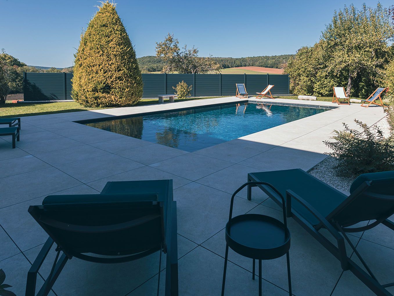 piscine rectangulaire ensoleillée avec terrasse