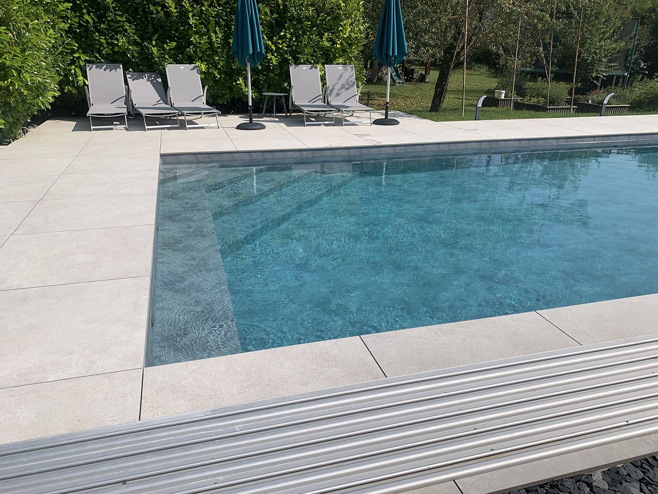 piscine rectangulaire ensoleillée avec terrasse